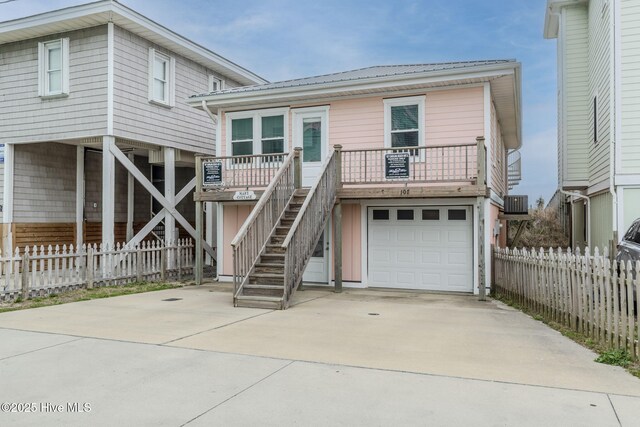 107 Carolina Beach Ave S, Carolina Beach, NC 28428 - view of front of house featuring a garage, concrete driveway, stairs, and fence