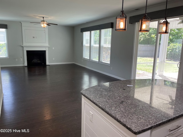kitchen with a healthy amount of sunlight, white cabinets, and a ceiling fan