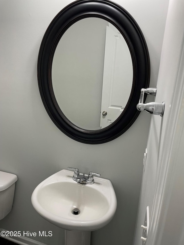 half bath featuring a sink and toilet