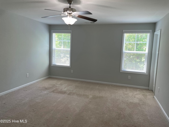 unfurnished room with ceiling fan, light carpet, and baseboards
