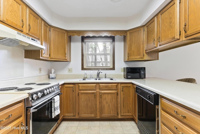kitchen with a sink, light tile patterned floors, light countertops, black appliances, and under cabinet range hood
