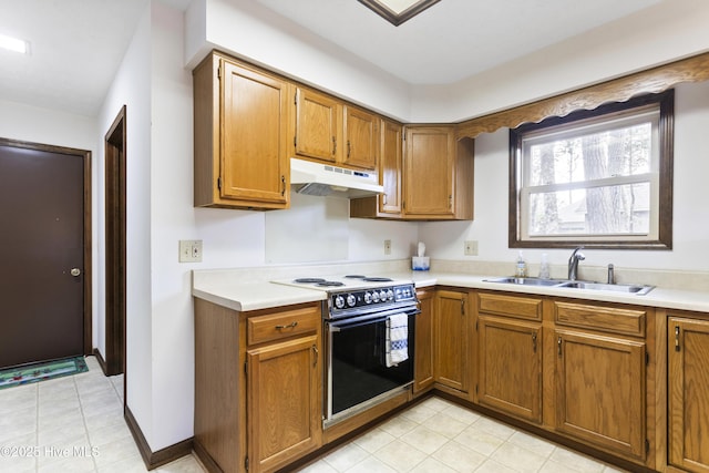 kitchen featuring brown cabinets, black range with electric stovetop, a sink, light countertops, and under cabinet range hood