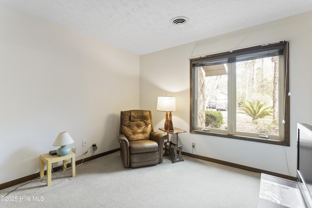 living area with carpet floors, baseboards, visible vents, and a wealth of natural light