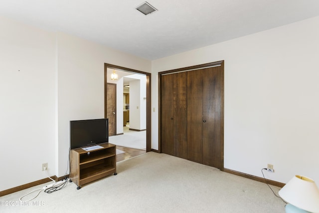 bedroom featuring baseboards, a closet, and light carpet