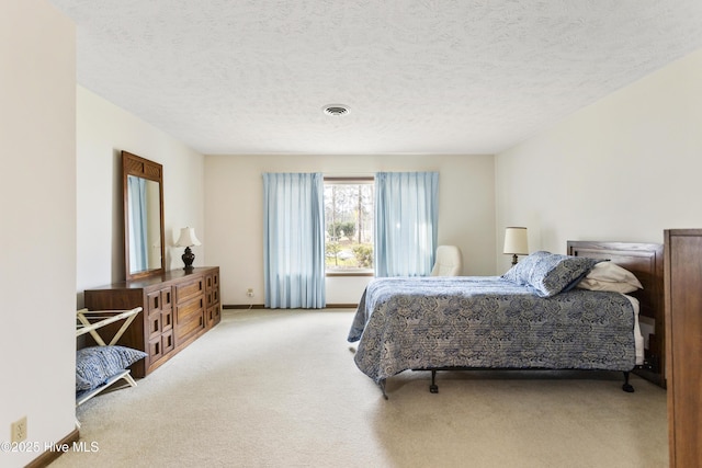 bedroom with carpet flooring, a textured ceiling, and visible vents