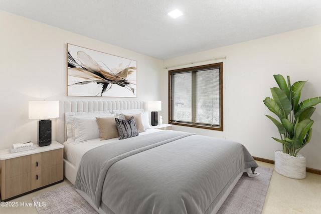 bedroom with baseboards and light carpet