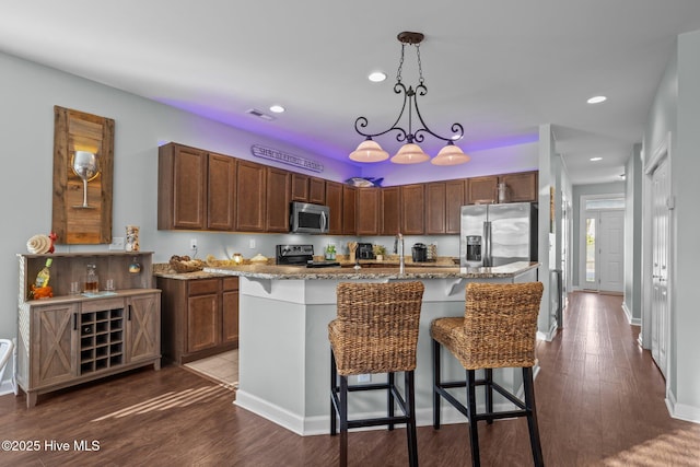 1203 Strange Ct, Morehead City, NC 28557 - kitchen with appliances with stainless steel finishes, light stone counters, recessed lighting, a kitchen bar, and pendant lighting