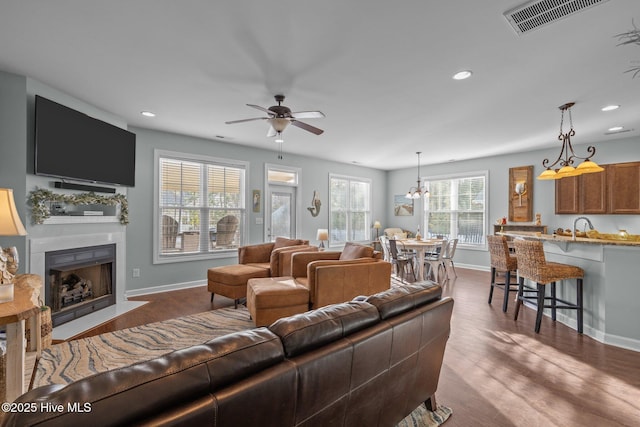 1203 Strange Ct, Morehead City, NC 28557 - living room with dark wood-type flooring, baseboards, a ceiling fan, a fireplace with flush hearth, and recessed lighting