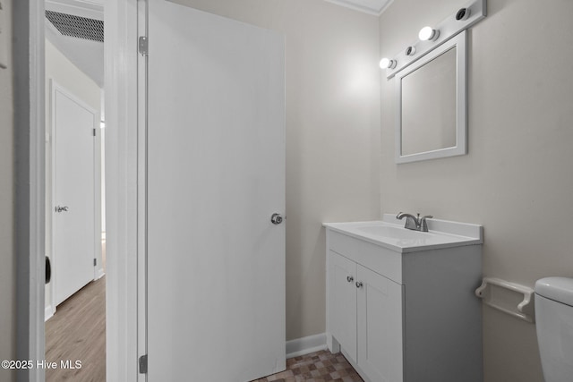 bathroom featuring visible vents, toilet, vanity, and baseboards