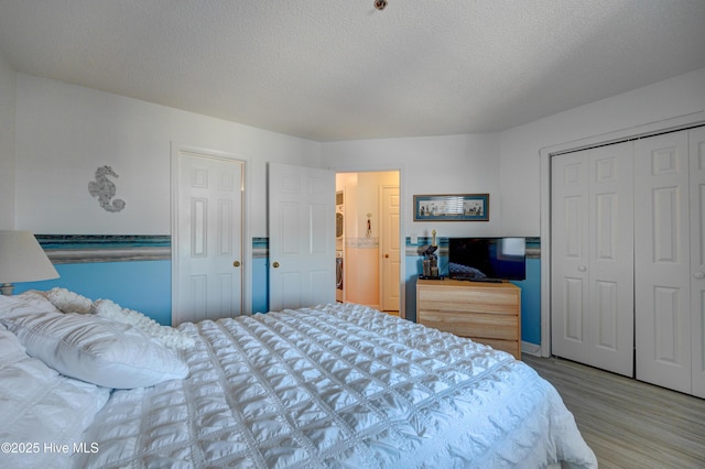 bedroom featuring wood finished floors, a closet, and a textured ceiling