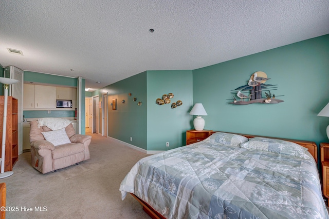 bedroom featuring baseboards, light colored carpet, visible vents, and a textured ceiling