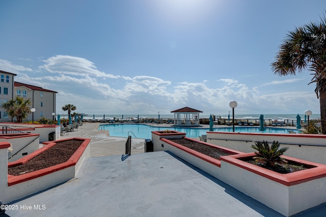 community pool featuring a water view and a patio