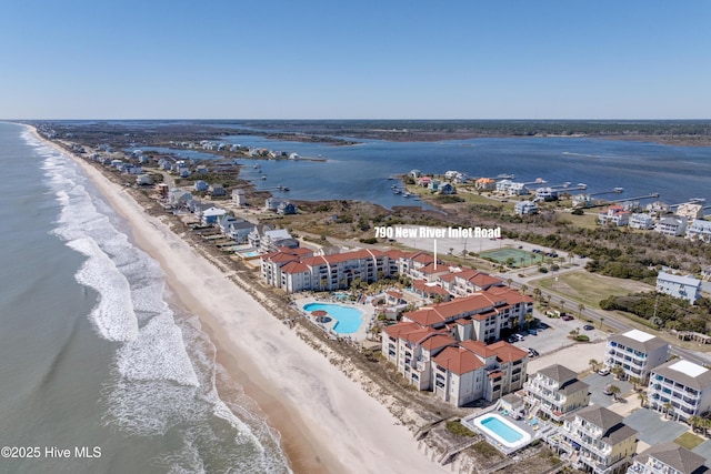 aerial view with a water view and a beach view