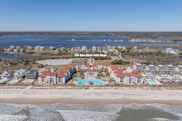 birds eye view of property with a view of the beach and a water view