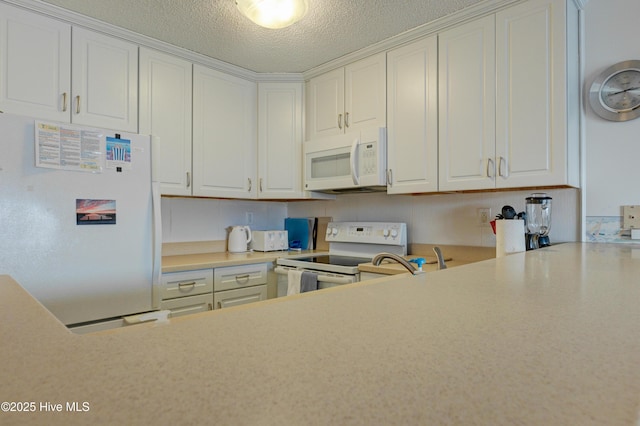 kitchen with white appliances, a textured ceiling, light countertops, and white cabinetry