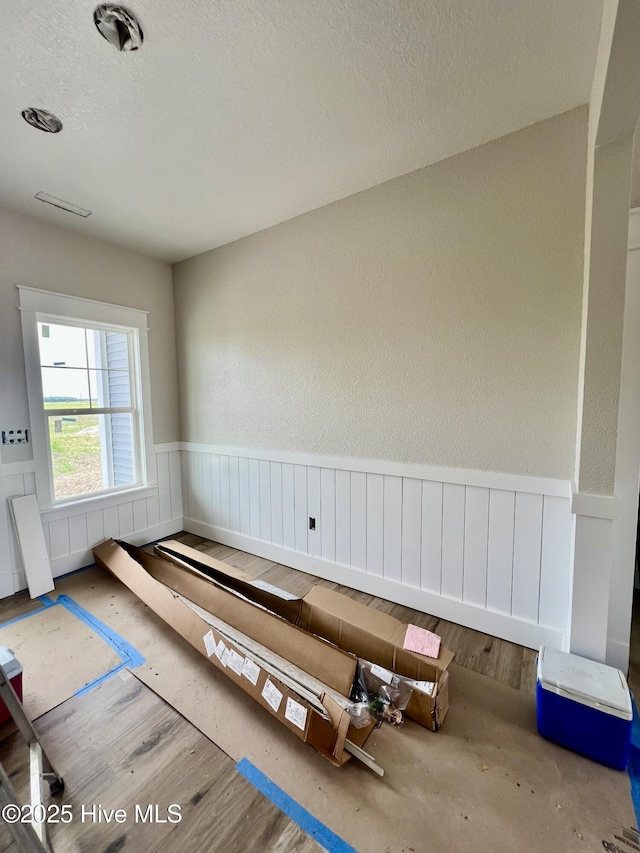 481 N Trotman Rd, Camden, NC 27921 - empty room with wainscoting, a textured ceiling, and wood finished floors