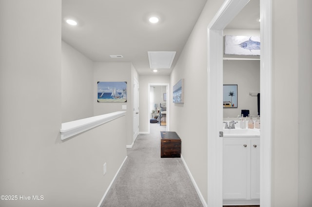 3659 Roseblossom Dr, Leland, NC 28451 - hallway featuring carpet, visible vents, baseboards, attic access, and a sink