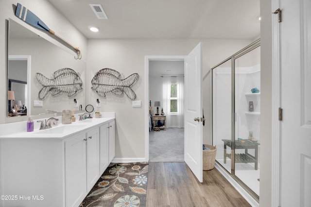 3659 Roseblossom Dr, Leland, NC 28451 - bathroom with visible vents, a sink, wood finished floors, a shower stall, and double vanity