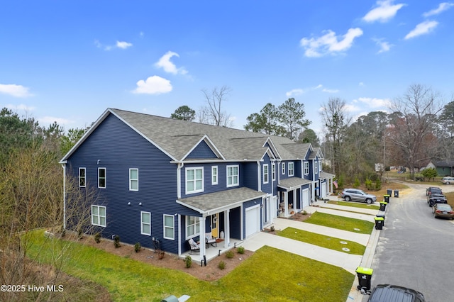 3659 Roseblossom Dr, Leland, NC 28451 - view of front of house with driveway, covered porch, roof with shingles, an attached garage, and a front yard