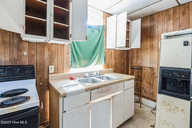 901 Daughtridge St, Rocky Mount, NC 27801 - kitchen featuring electric range, wood walls, a sink, white refrigerator with ice dispenser, and white cabinets