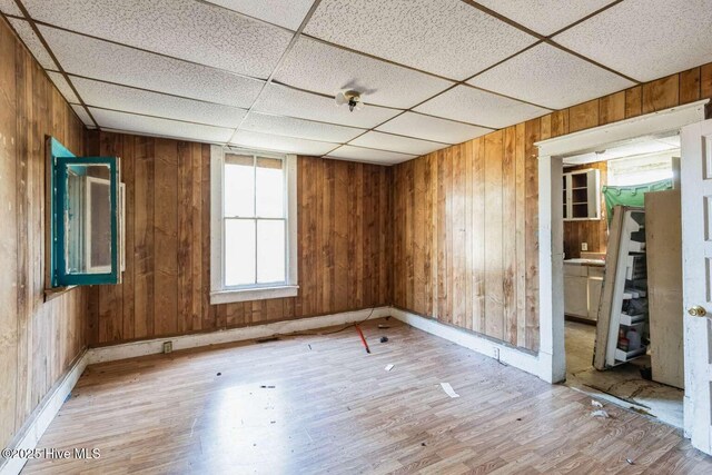 901 Daughtridge St, Rocky Mount, NC 27801 - unfurnished room with light wood finished floors, wood walls, baseboards, and a paneled ceiling