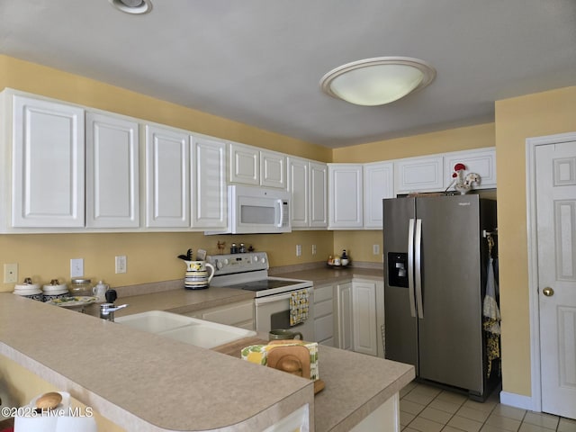 405 Commerce Ave Unit A, Morehead City, NC 28557 - kitchen with a peninsula, light countertops, white appliances, and white cabinetry