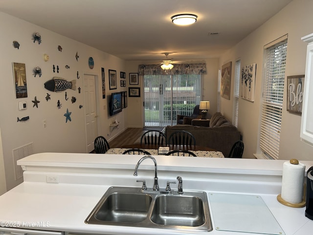 kitchen featuring visible vents, a sink, a ceiling fan, and light countertops