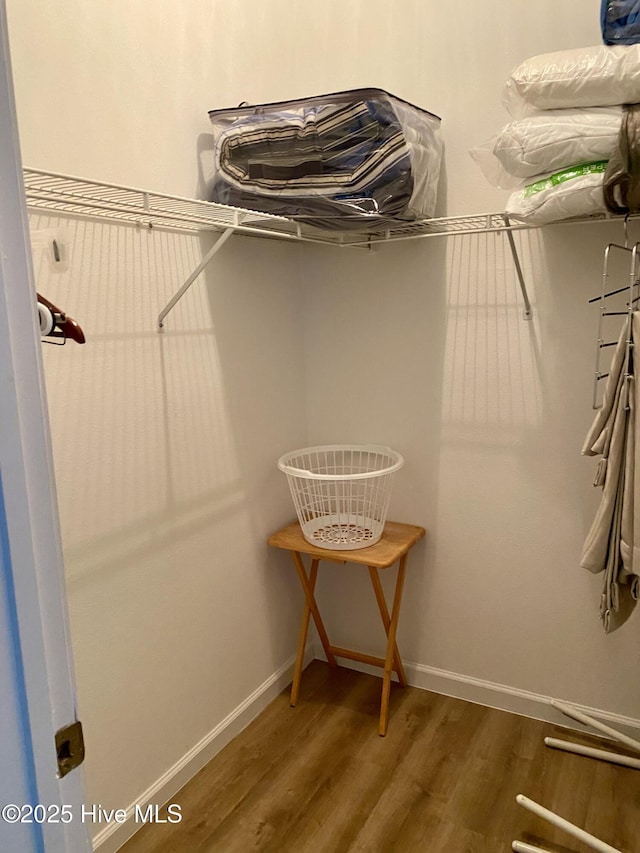 walk in closet with wood finished floors