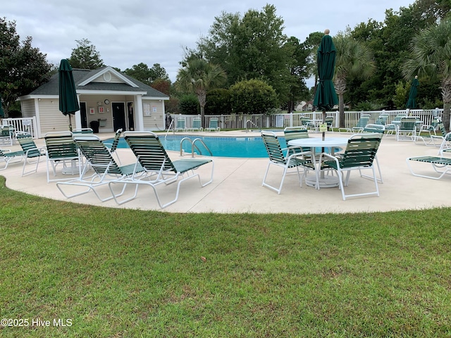 pool featuring fence, a lawn, and a patio area
