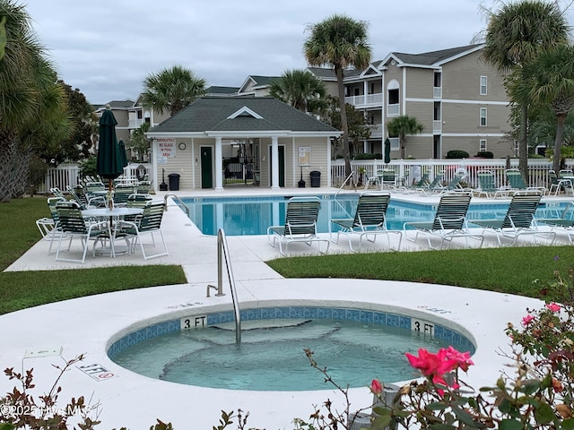 pool featuring a patio, a community hot tub, and fence
