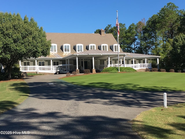 farmhouse with covered porch, a standing seam roof, and metal roof