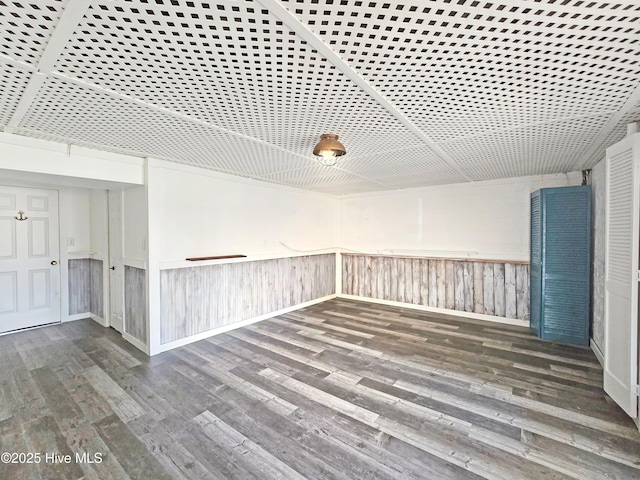 unfurnished room featuring wood finished floors and wainscoting