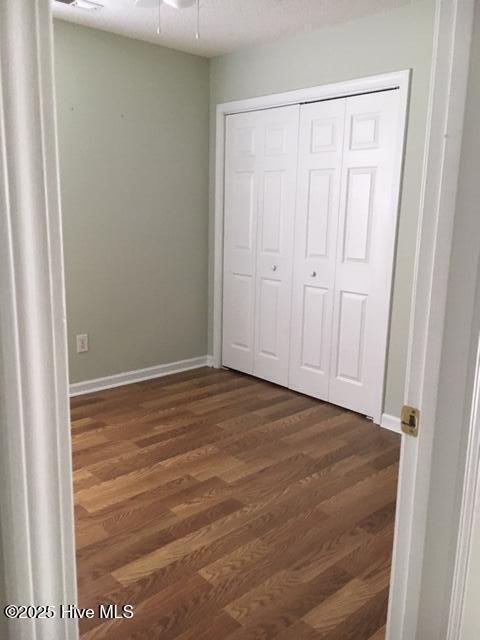 1008 S 10th St, Wilmington, NC 28401 - unfurnished bedroom featuring dark wood finished floors, baseboards, and a closet