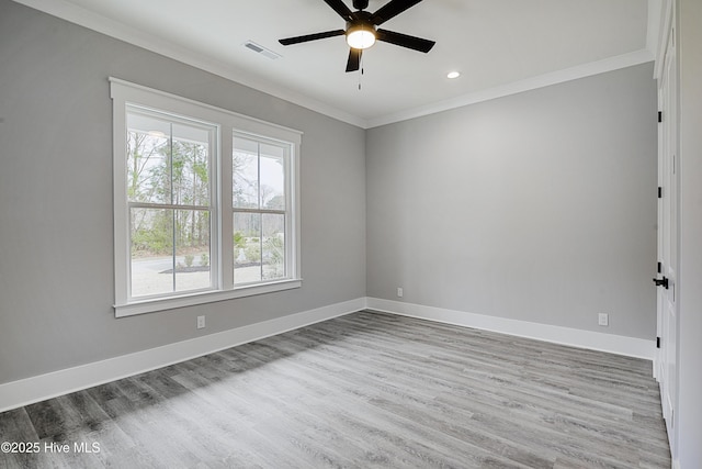 unfurnished room featuring visible vents, ornamental molding, wood finished floors, baseboards, and ceiling fan