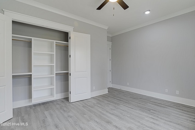 unfurnished bedroom with baseboards, ornamental molding, wood finished floors, a closet, and a ceiling fan