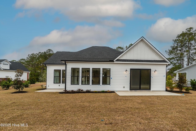 rear view of property featuring a yard, a patio area, board and batten siding, and a shingled roof