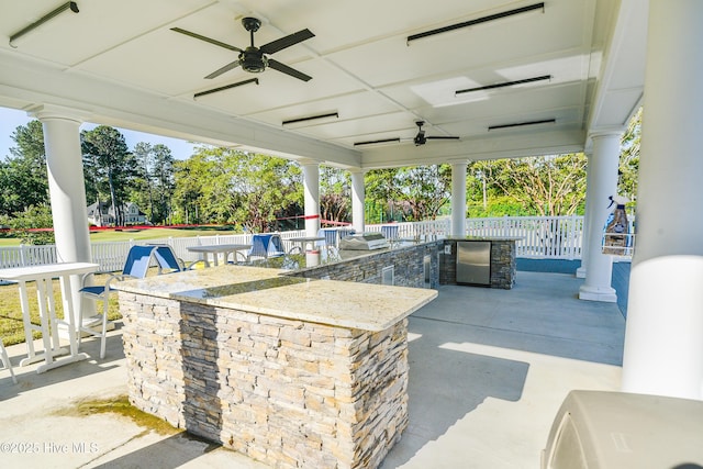 view of patio featuring outdoor wet bar, fence, and ceiling fan