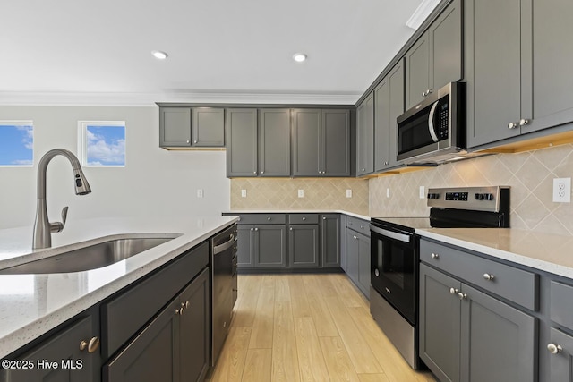 3700 Cessna Way W, Wilson, NC 27896 - kitchen featuring appliances with stainless steel finishes, a sink, light stone counters, crown molding, and light wood-style flooring