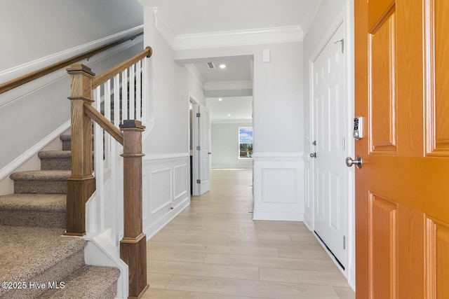 3700 Cessna Way W, Wilson, NC 27896 - entrance foyer with ornamental molding, light wood finished floors, a decorative wall, stairs, and a wainscoted wall