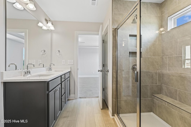 3700 Cessna Way W, Wilson, NC 27896 - bathroom with double vanity, a stall shower, wood finished floors, and baseboards