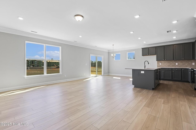 3700 Cessna Way W, Wilson, NC 27896 - kitchen featuring open floor plan, ornamental molding, light wood-style floors, a kitchen island with sink, and tasteful backsplash