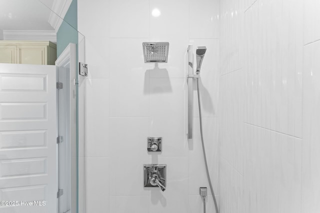 full bathroom with a tile shower and ornamental molding