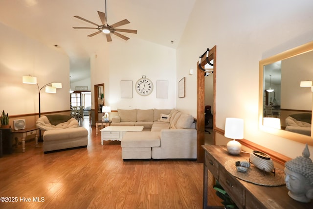 living area featuring wood finished floors, high vaulted ceiling, and ceiling fan