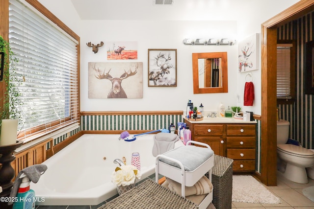 full bathroom featuring toilet, visible vents, tile patterned flooring, a tub with jets, and vanity