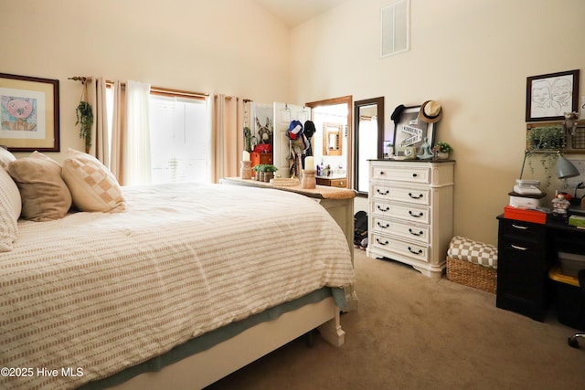 bedroom featuring high vaulted ceiling, carpet flooring, and visible vents