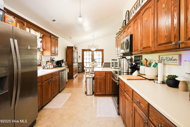 kitchen with light countertops, vaulted ceiling, brown cabinetry, and stainless steel appliances