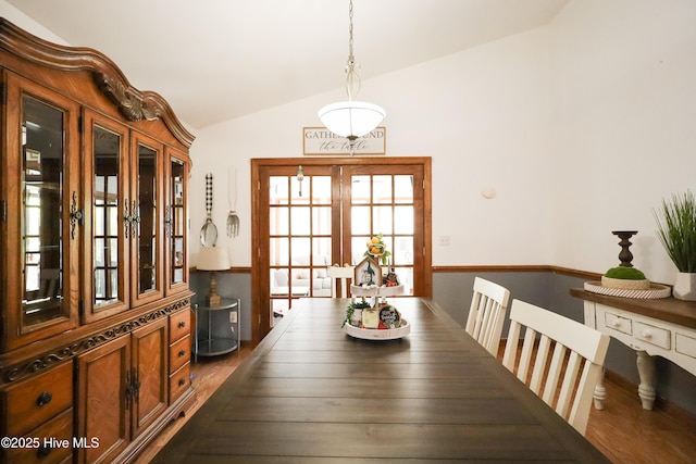 dining area with lofted ceiling and french doors