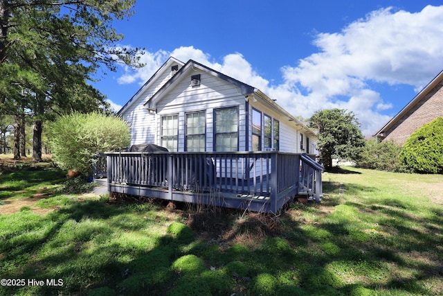 back of house featuring a yard and a deck