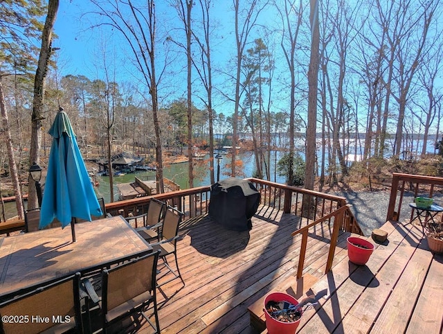 deck featuring a water view, area for grilling, and a boat dock
