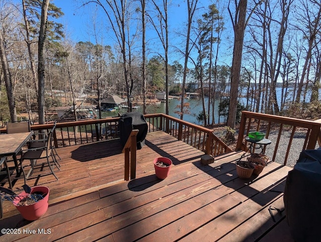 wooden terrace with a water view and a grill